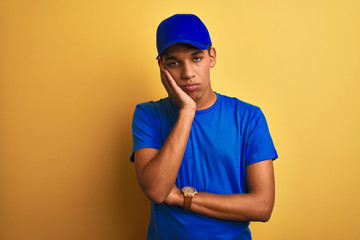 Young handsome arab delivery man standing over isolated yellow background thinking looking tired and bored with depression problems with crossed arms.
