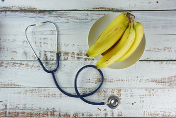 Selective focus of bunch of bananas and stethoscope.