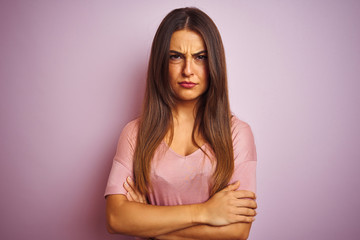 Obraz premium Young beautiful woman wearing t-shirt standing over isolated pink background skeptic and nervous, disapproving expression on face with crossed arms. Negative person.