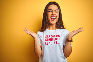 Beautiful woman wearing fanny t-shirt with irony comments over isolated yellow background...