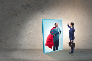Businessman seeing himself in mirror as superhero