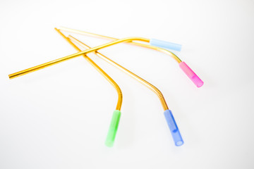 Bent stainless steel metal multicolor reusable straws with a blue, pink and green silicone straw tips on a white background.