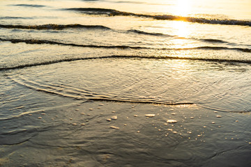 Beautiful texture of sea water surface at the beach during the sunrise.