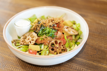 Japanese salad made with organic vegetables and Japanese seaweed dripped with Wasabi salad cream sauce. Served on wooden table in the Japanese's restaurant.