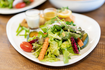 Japanese salad made with organic vegetables and Japanese seaweed dripped with Wasabi salad cream sauce. Served on wooden table in the Japanese's restaurant.