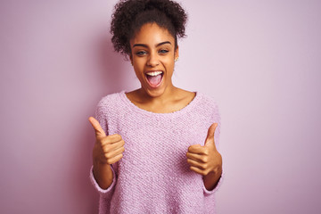 Young african american woman wearing winter sweater standing over isolated pink background success...