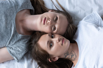top view of two lesbians lying in bed together