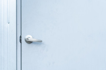 Metal door knob, door handle, in metal door close up.