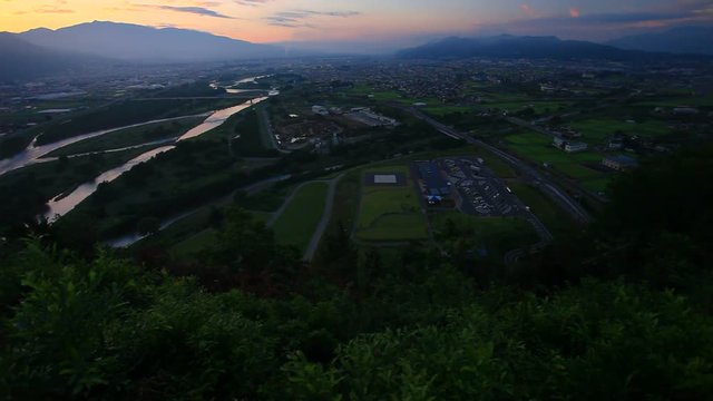 Tilt up of Chikuma River, Ueda City and Uedahara at sunrise, Japan
