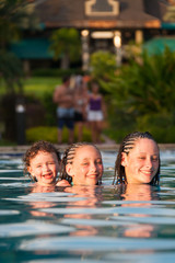 Obraz premium Three children playing piggyback while swimming in a pool in Cruz Bay, St. John, USVI