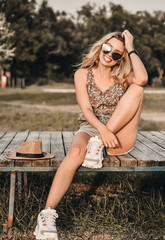 Beautiful young woman in stylish hat with summer cold drink has a fun outdoors.