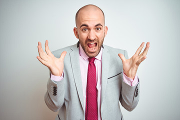 Young business man wearing suit and purple tie over isolated background celebrating crazy and amazed for success with arms raised and open eyes screaming excited. Winner concept