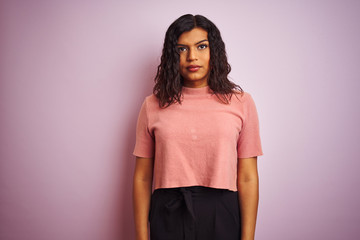 Obraz premium Young beautiful transsexual transgender elegant woman over isolated pink background with serious expression on face. Simple and natural looking at the camera.