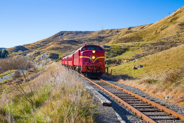 A locomotive takes tourists along the Weka Pass Railway through scenic limestone outcrops and past vineyards from Waipara to Waikari in Canterbury, New Zealand