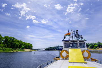 River cruise ferry with Belarusian flag sailing across river Sozh in Gomel, Belarus