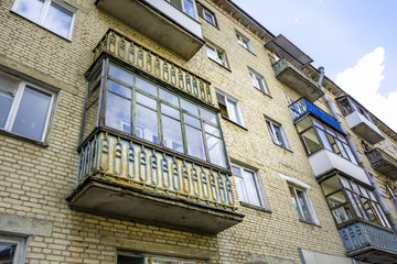 Fototapeta na wymiar Old soviet style brick building with decaying balconies