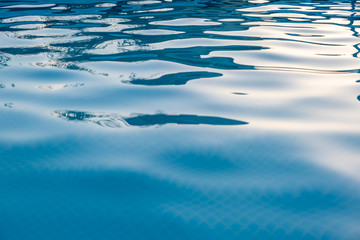 Ripples in pool blue water with light and shadow play background
