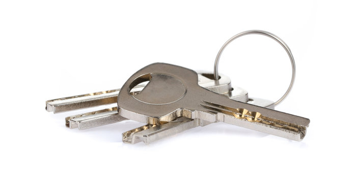 Four house keys on a key ring isolated on a white background.