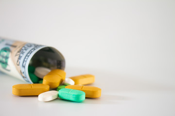 Money from the United States with vibrantly colored medicines on a neutral white background. Concept of health cost. Concept of drug trafficking.