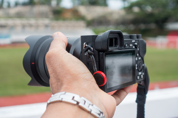 Male hand holding a digital camera.