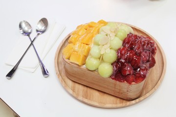 Bingsu or Bingsoo is a Korean shaved ice dessert with fresh fruit , Decorated with melons on ice.