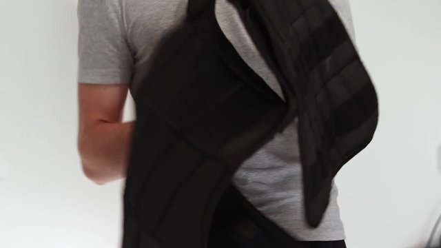 An athlete puts on a weight vest.