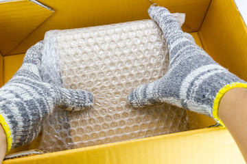hand of man hold Bubbles covering the box by bubble wrap for protection product