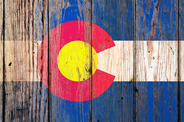 Colorado US state national flag on a gray wooden boards background on the day of independence in different colors of blue red and yellow. Political and religious disputes, customs and delivery.