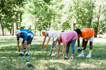 multicultural group of pensioners doing stretching exercise on grass