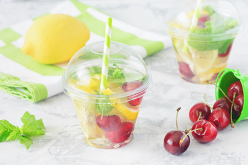 Fruit Water Glass Citrus Slice Berry Mint Beverage. Slimming Diet Beverage and Weight Loss Concept. Natural Flavored Soda. Vegan Party Food. Fresh Lemon on Striped Napkin Elevated View