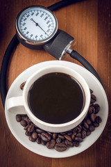 Coffee and blood pressure, a concept image with a coffee cup sorrounded by a sphygmomanometer