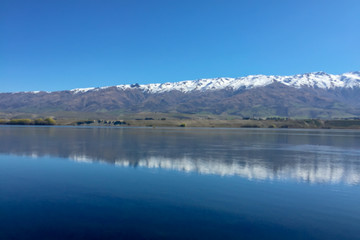 Fototapeta na wymiar Snow capped Southern Alps overlooking beautiful lake scenes in the South Island New Zealand