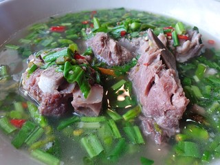 Thai food style, Selective focus of hot and spicy pork neck bones soup in white bowl as a background, This food is most popular Thai food, Lang Zap or Tom Yam is Thai traditional