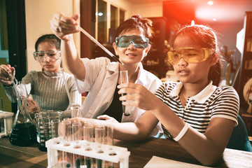 asian teacher and student in school science laboratory room