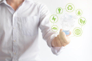 Hand holding twisted plastic bottle with  virtual effect icon about environment, Global warming solution, Environment concept