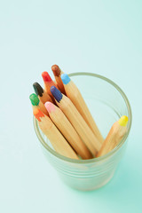 Colorful pencils on pastel pale blue