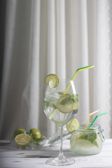 Refreshing mojito cocktail with lime and mint in a tall glass on a light background