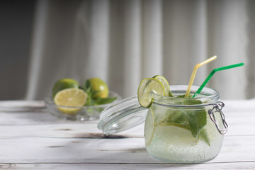 Mojito cocktail with mint and lime with ice in a jar on a light background