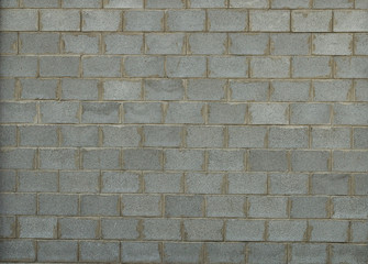 Old conctete blocks wall texture background. Exterior grey cinder block wall with lines of concrete. Cinder block wall background