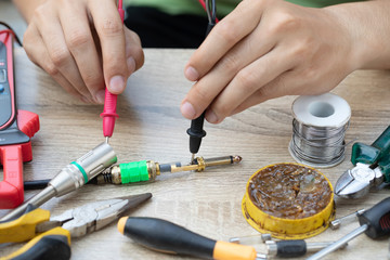 Fototapeta na wymiar Electronic technician are soldering balanced Jack for connecting digital signal.