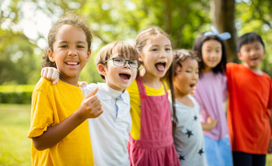 Multi-ethnic group of school children laughing and embracing