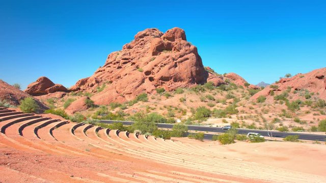 Phoenix AZ Papago Amphitheater Landscape with Seating and Highway Vehicle Traffic on McDowell Road Driving Past the Public Entertainment Venue on a Sunny Day in Arizona