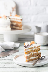 Healthy homemade carrot cake with cream cheese frosting on white wooden table