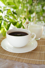 Obraz na płótnie Canvas Milk and coffee cup on bamboo mat