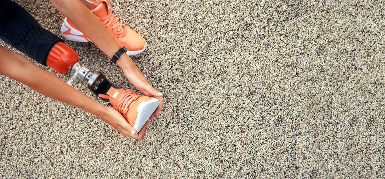 Top view of woman stretching her prosthetic leg. Web banner - Powered by Adobe