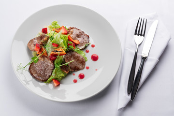 beef stake with strawberry on white dish