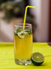 glass of fresh mojito with lime on a yellow background, a drink close-up