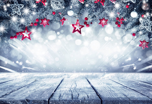 Festive Christmas stage scene  background framing. Fir branches decorated with stars and red berries and empty wooden flooring platform. Beautiful round bokeh, copy space.