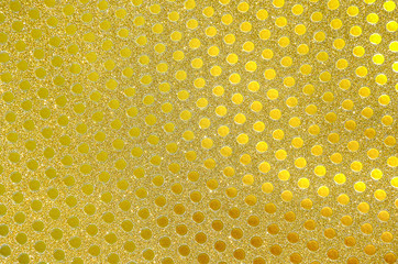 Golden wrapping paper, flickering small circles pattern as background or texture