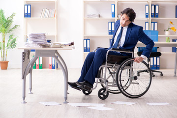 Young male employee in wheelchair working in the office
